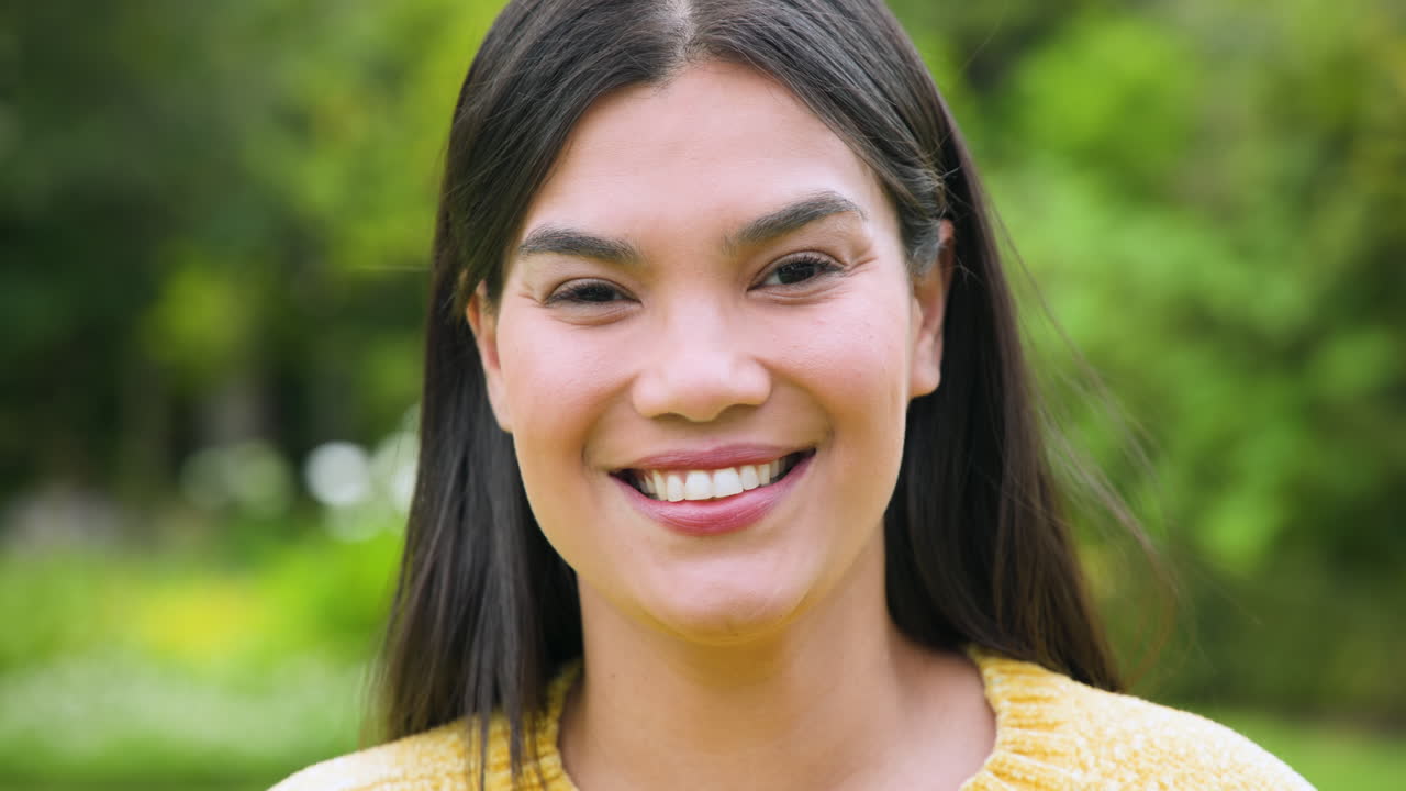 Smiling woman enjoying sunny day outdoors in lush green park