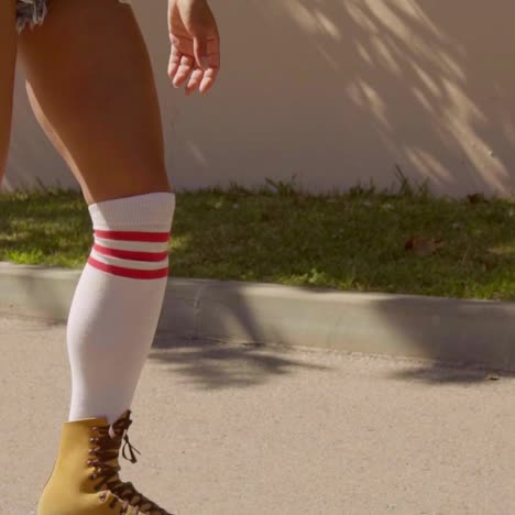 female legs on vintage roller skater on the road