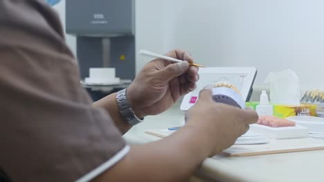 captura de pantalla de un técnico que prepara una dentadura postiza