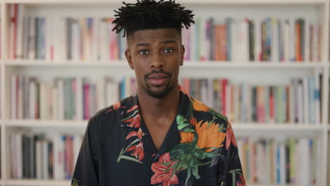 retrato apuesto hombre afroamericano estudiante con aspecto confiado joven hombre negro con camisa hawaiana peinado funky cámara lenta