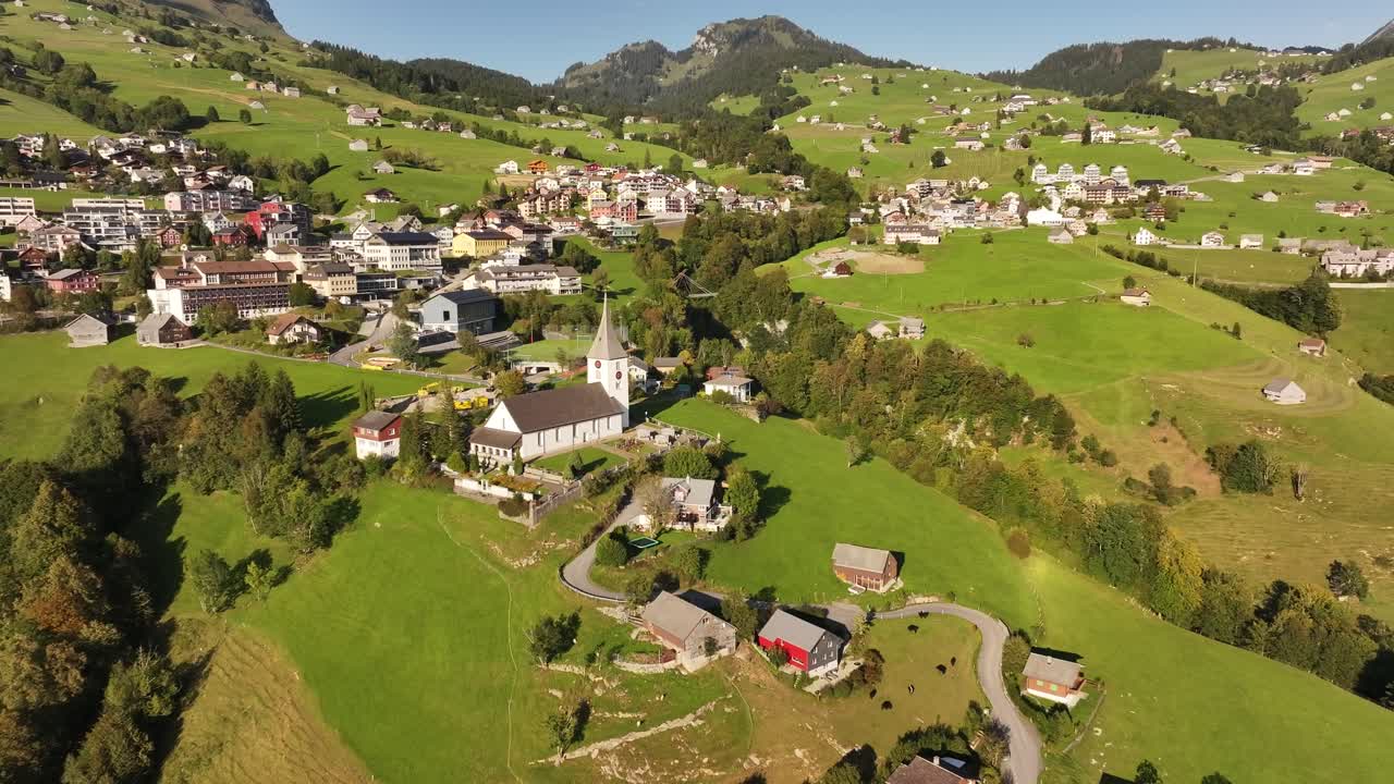 Aerial View of a Charming Swiss Village Nestled in Green Mountains