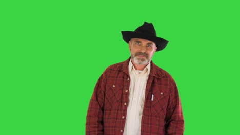 adult smiling man in black cowboy hat walking on a green screen, chroma key