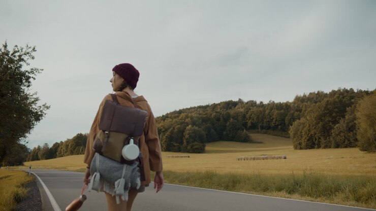 Young female explorer walking on road against sky