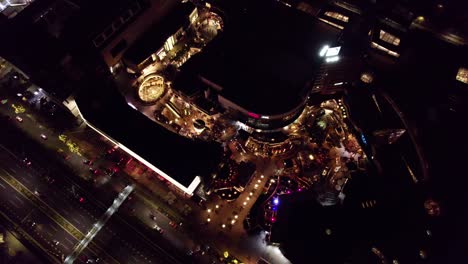 aerial top down orbit of parque arauco luxurious shopping mall illuminated at night, las condes, santiago, chile