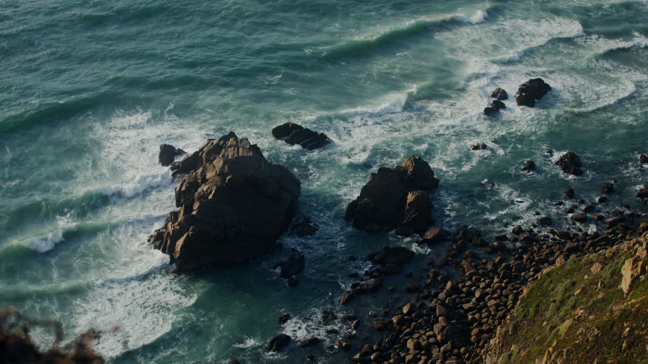 Le onde dell'oceano si schiantano sulla riva rocciosa
