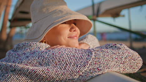 mujer sonriente soñando con la luz del sol al aire libre en primer plano. feliz modelo tranquilo en sombrero disfrutar