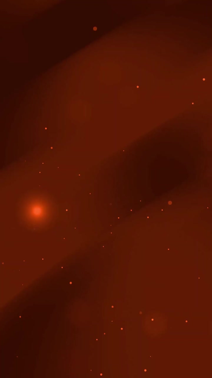 Particelle bokeh dinamiche rosse e arancioni che fluttuano nello spazio scuro