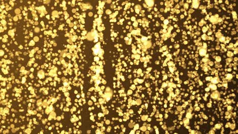 4k gold shining golden dust dust particles slowly floating in the air. glimmering on black background.