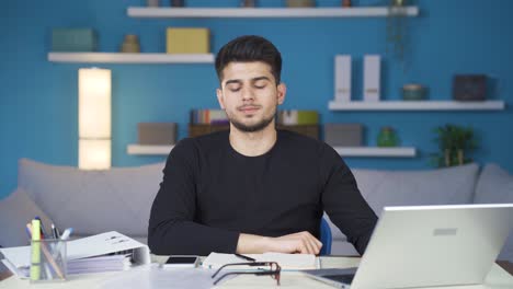 Young-man-working-from-home-is-stressed-and-overwhelmed-with-work.