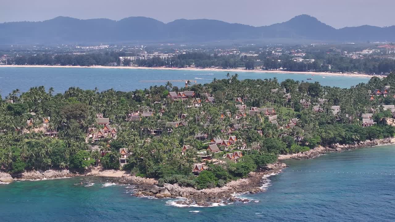 Small resort town with luxury accomodation in Phuket, Thailand. Drone reveal horizon.