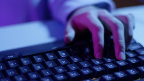 close up boy using keyboard to play video game