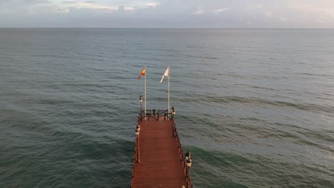 Wooden-jetty-on-the-Mediterranean-sea-with-people-walking-on-it