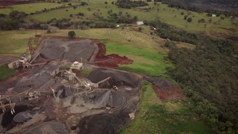 aerial view over an open quarry in brazil on the side of the iguazu river near foz do iguazu with the rock piles and excavators