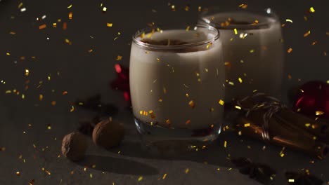 Animation-of-confetti-falling-over-christmas-drinks-and-decoration