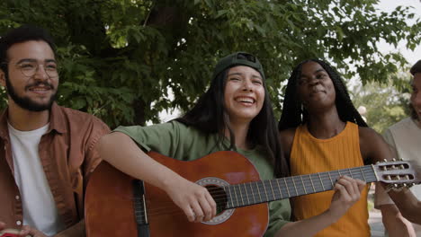diverse group of friends playing music together outdoors