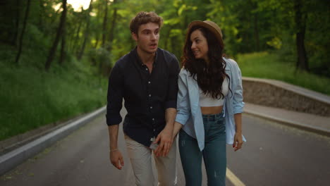 una pareja de amor caminando por la carretera. una chica y un chico alegres saltando por la carretera al aire libre.