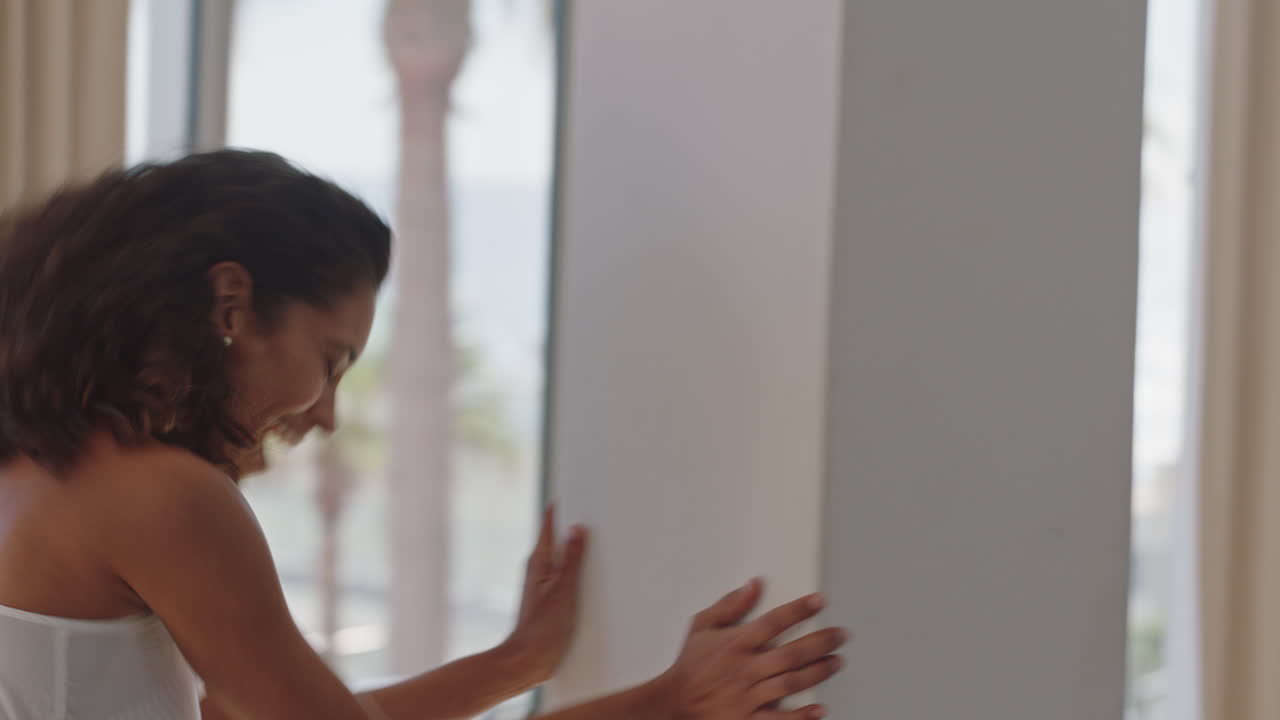 여행하는 여성이 호텔 방에서 춤을 추고 즐겁게 여름 휴가를 축하하고 무모한 휴가 라이프 스타일을 즐기고 있습니다.