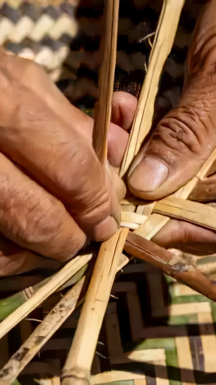 Video vertikal: Memposisikan strip, tangan mengarahkan ke dalam keranjang di atas tikar anyaman dengan jari-jari bambu
