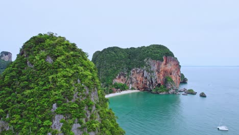 Drohnenaufnahme-Eines-Sockels,-Der-über-Kalksteinfelsen-Aufsteigt-Und-Den-Phra-Nang-Beach-In-Railay,-Thailand-Zeigt