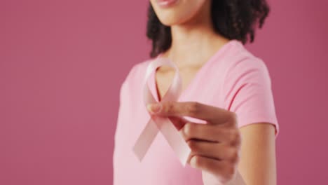 Video-Einer-Gemischtrassigen-Frau,-Die-Ihr-Rosa-Brustkrebsband-Hält
