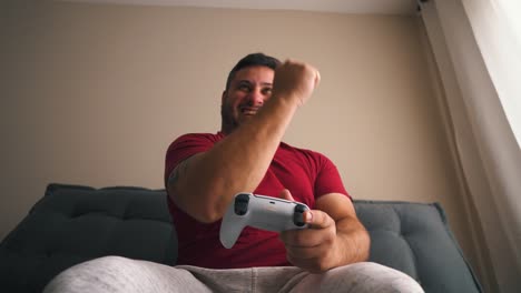 young man celebrating victory playing video games