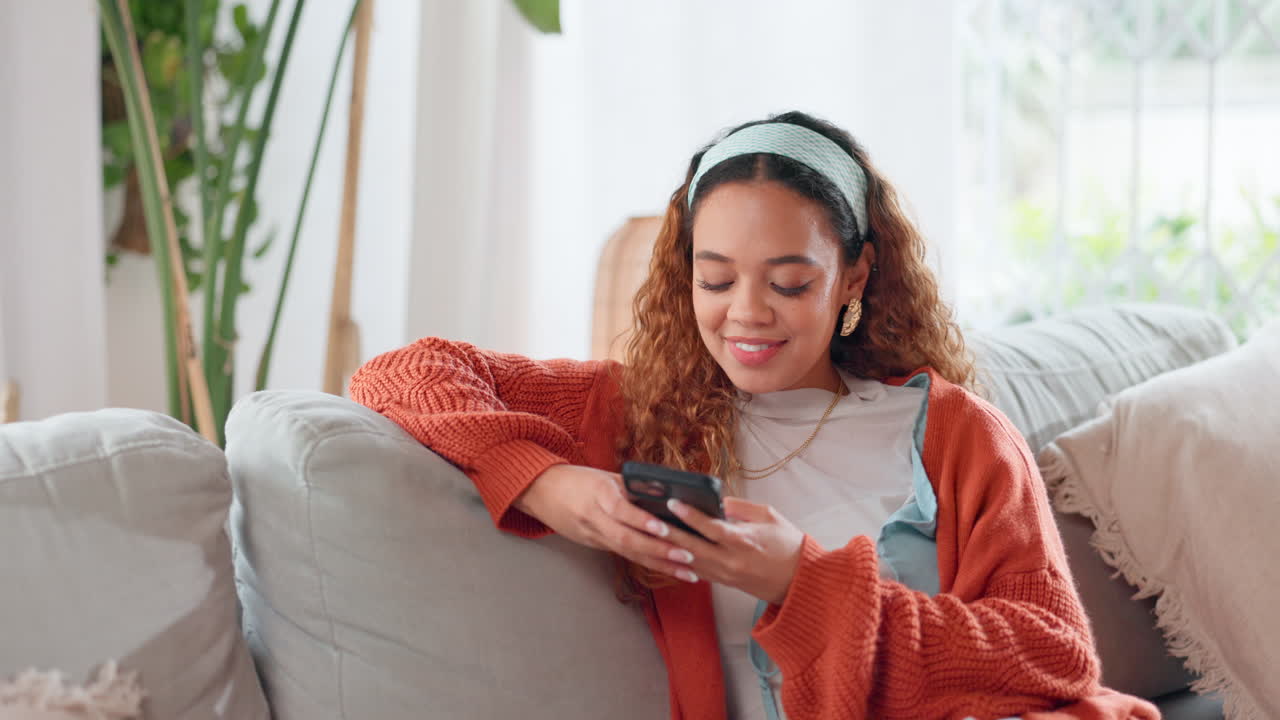 Donna che si rilassa sul divano e usa il suo smartphone.