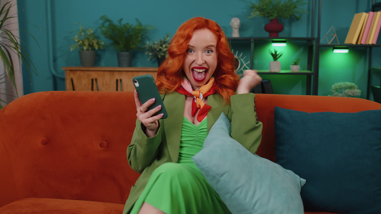 chica pelirroja en casa usar teléfono inteligente escribir navegación, wow sí descubrió gran gran victoria celebrar