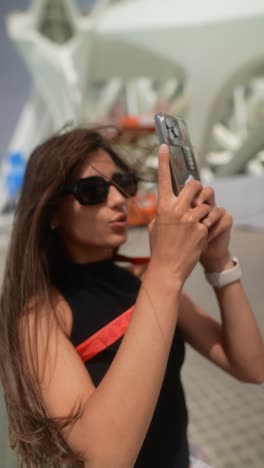 woman taking a photo in a city