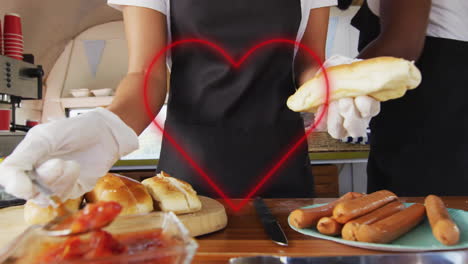 preparing hot dogs, people in kitchen with heart animation over scene