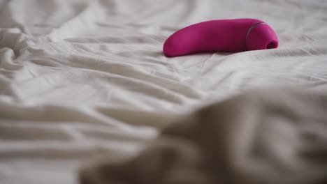 foco de rack de sábanas grises a vibrador rosa en sábanas