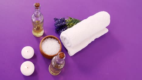 sal de mar en un cuenco de madera, toalla, aceite, vela y flores