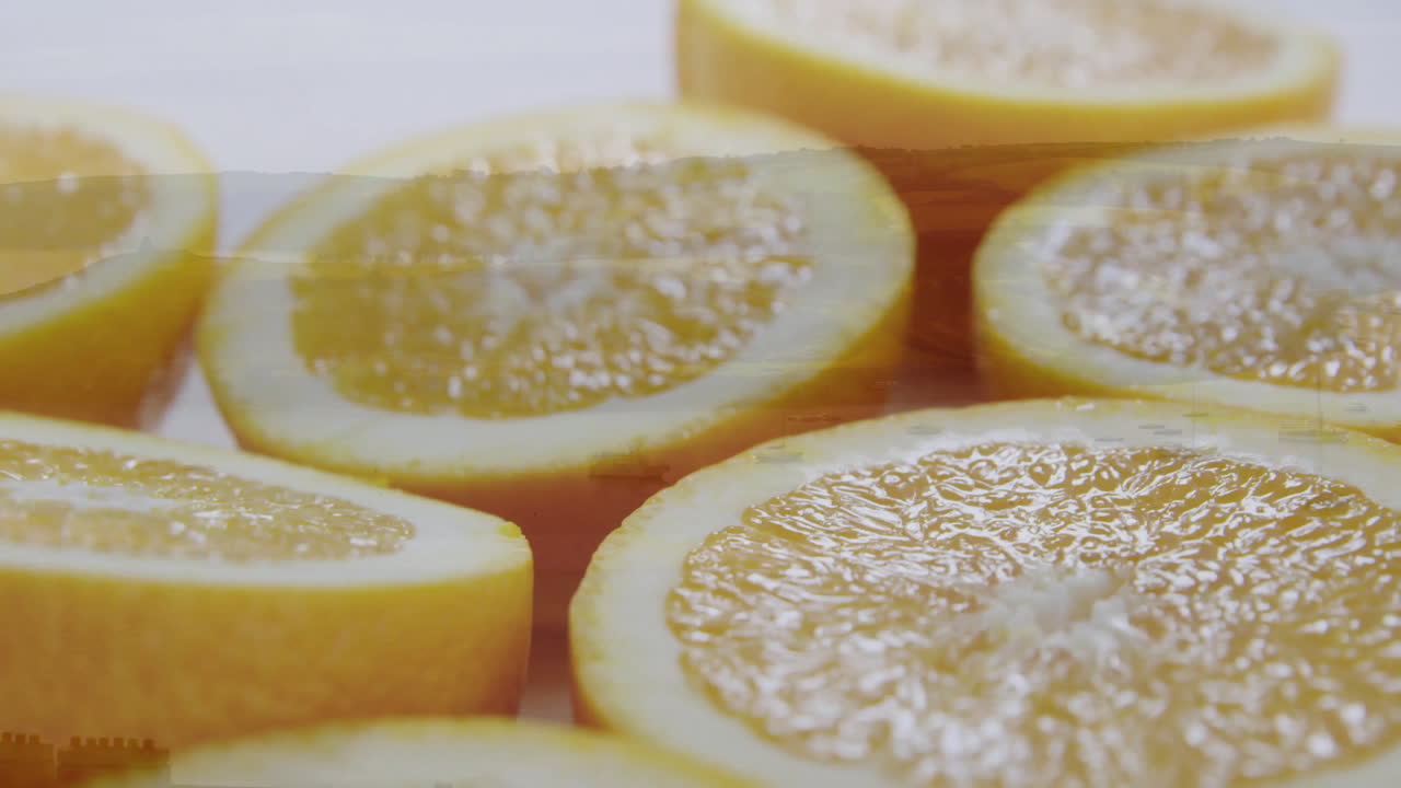 Fresh lemon slices arranged closely on light surface, creating bright pattern