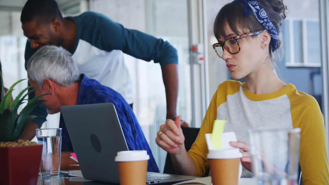 Attentive executive writing in diary while using laptop