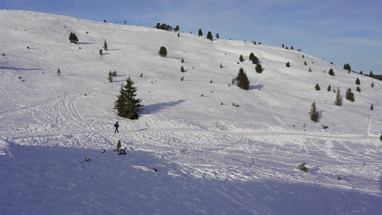 одинокий пеший турист идет по заснеженной тропе в горной глуши в альпах