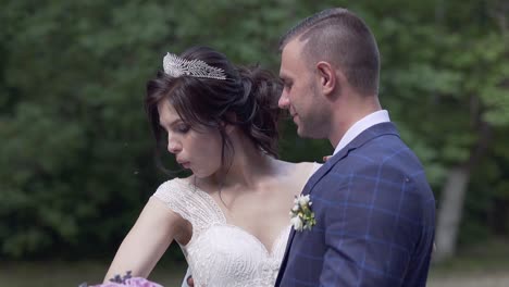 slow motion wedding couple hugs and bride blows on shoulder