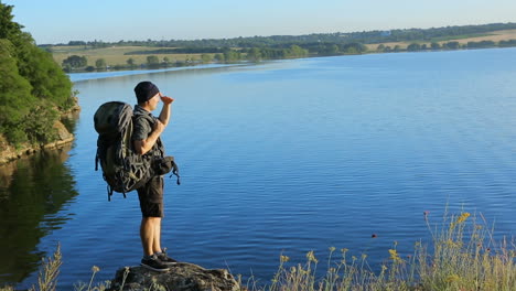 hiker looking at sunset. successful adult man hiker enjoy the viewpoint on a stone
