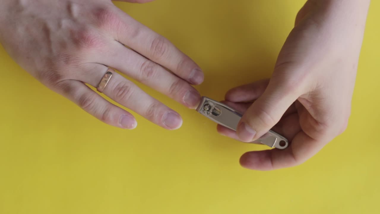cortar las uñas para lograr un aspecto bien recortado sobre un fondo amarillo