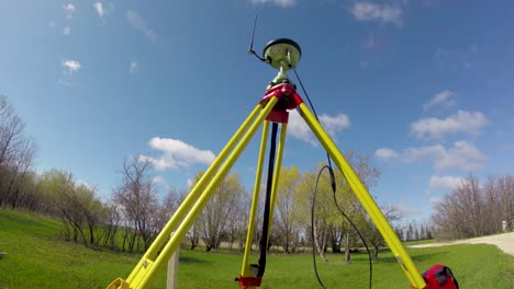 timelapse of leica gnss base station for land surveying with clouds moving by, on a summer day in st