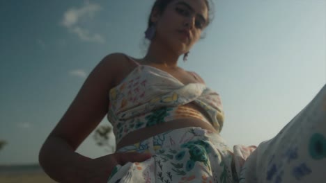 Feliz-Joven-Adulta-Hipster-Gen-Z-Adolescente-Chica-Cara-Seria-Con-Pelo-De-Nudo-Y-Piercing-En-La-Nariz-Usando-Aretes-Mirando-A-La-Cámara-Posando-En-La-Playa,-Retrato-De-Cuerpo-De-Cabeza-Soleada