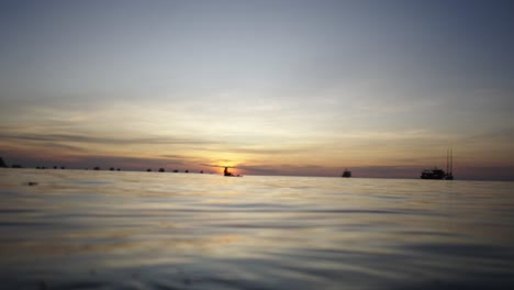 Tranquil ocean sunset with silhouetted boats