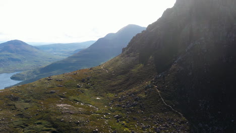 Cinematic-drone-shot-of-Stac-Pollaidh-in-the-Northwest-Highlands-of-Scotland,-with-a-mountain-trail-on-the-side-of-the-mountain