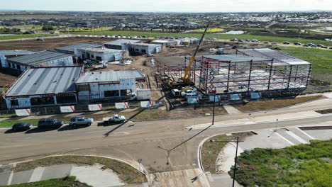 Flächenaufnahmen-Der-Baustelle-In-Melbourne-West-Crane,-Der-An-Einem-Schönen-Tag-Mit-Vielen-Autos-Dji-Drohnenschlamm-An-Einem-Neuen-Einkaufszentrum-Arbeitet