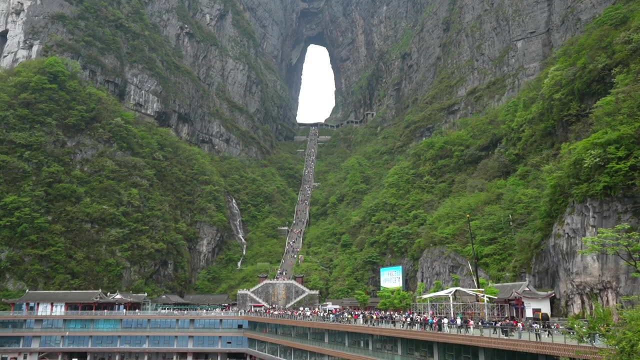 湖南省張家界の天門山にある素晴らしい天然の岩のアーチを訪れる大勢の人々。
