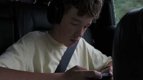 teenager using a smartphone in a car