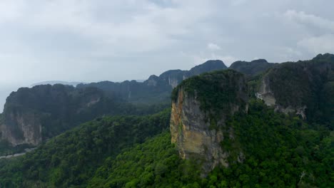 drone shot of railay beach and mountains with longtail boats passing by