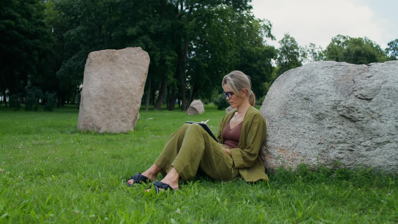 Mulher desenhando em tablet no parque
