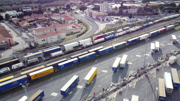 Aerial View of Freight Terminal with Trains and Trucks