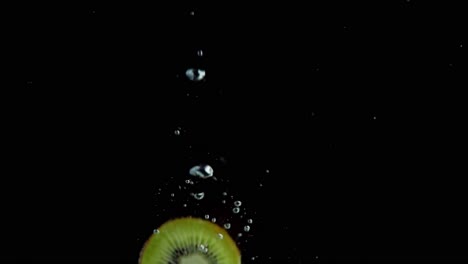 kiwi falling into water super slowmotion, black background, lots of air bubbles, 4k240fps