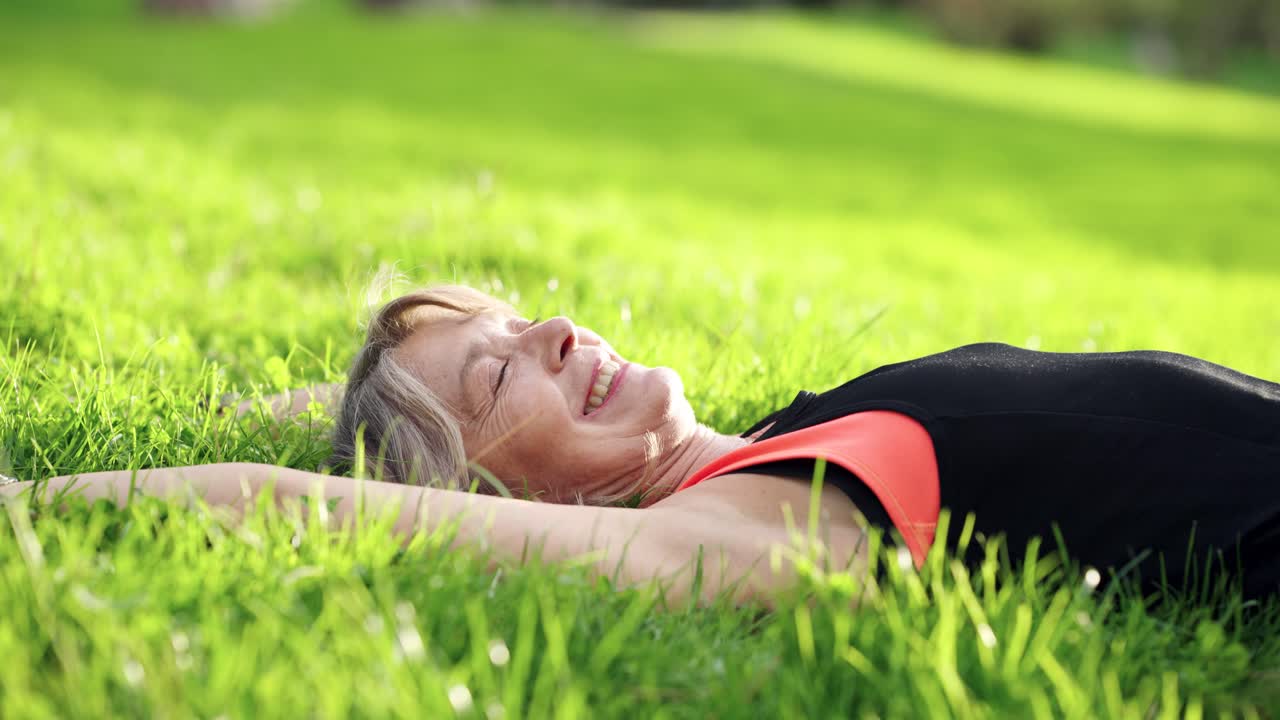 Senior woman lying on grass