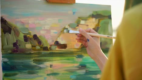 una mujer pintando un paisaje.
